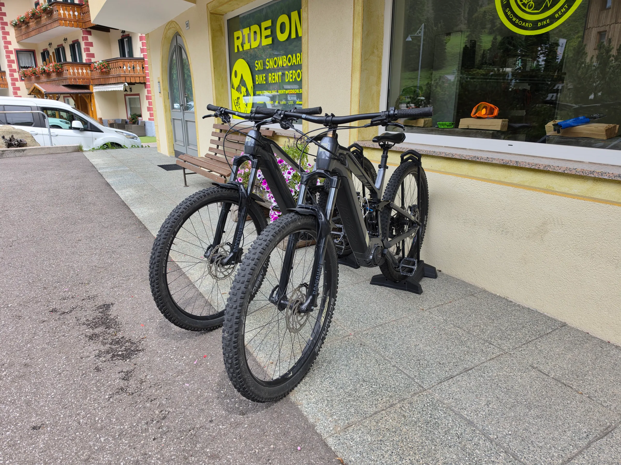 Due e-bike Conway davanti al negozio RIDE ON ad Alba di Canazei, montagne sullo sfondo